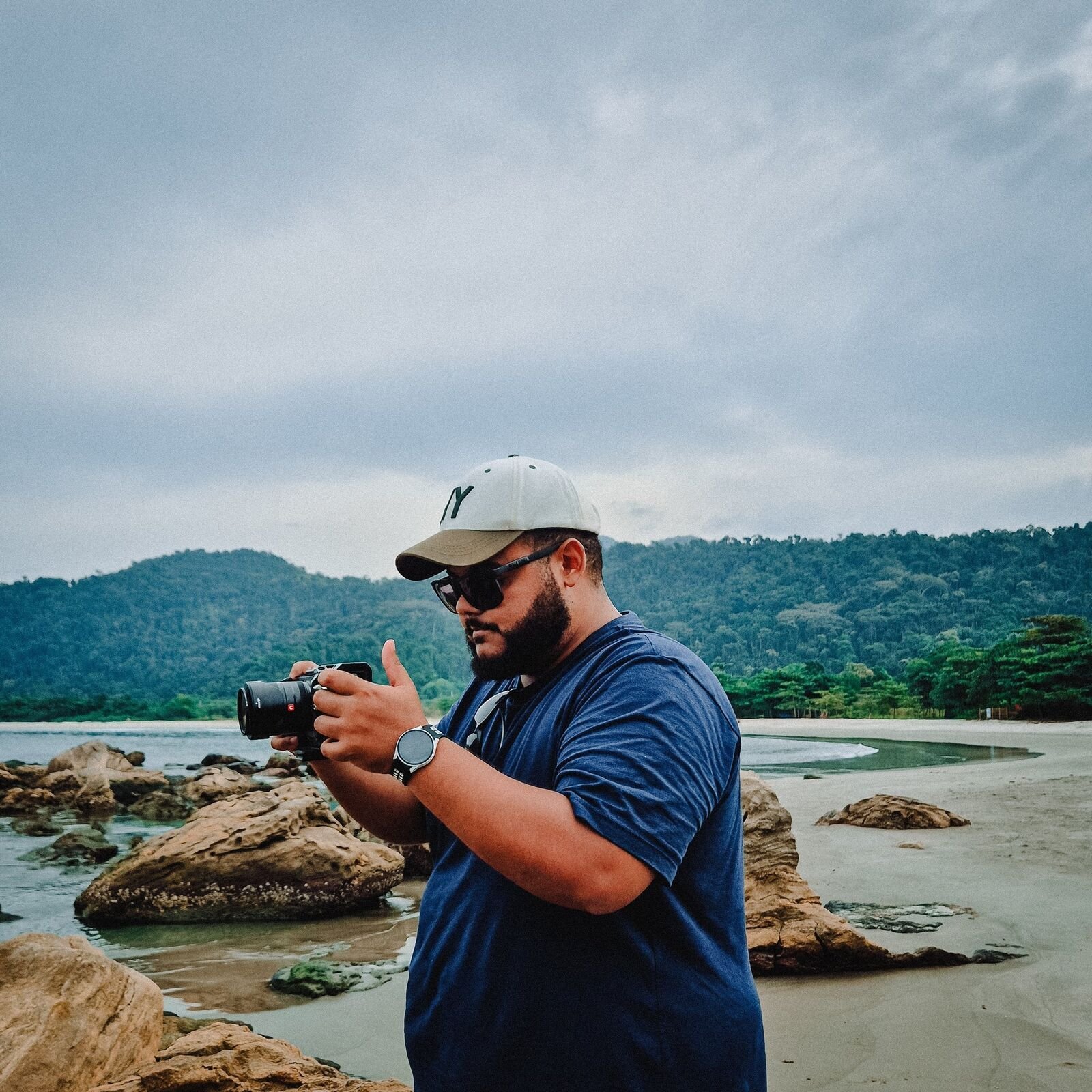 Lucas photographing on the rocky shore